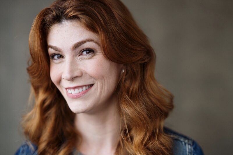 Executive functioning coach with red hair smiling warmly